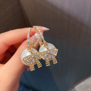 Øreringe med glitrende sløjfer og perler i guld
